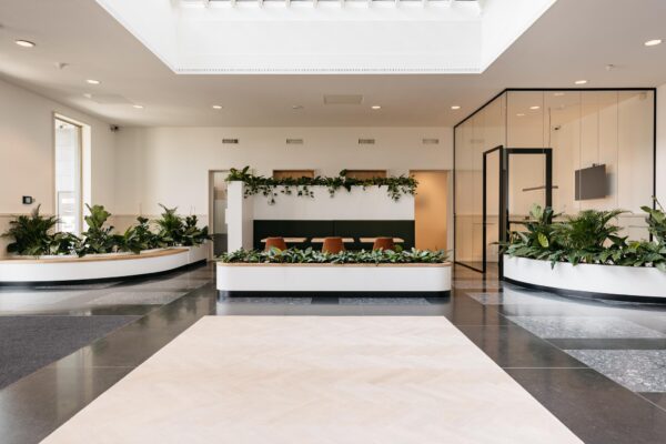 Moderne en lichte kantoorlobby aan de Fascinatio Boulevard met veel groen en een zitgedeelte.